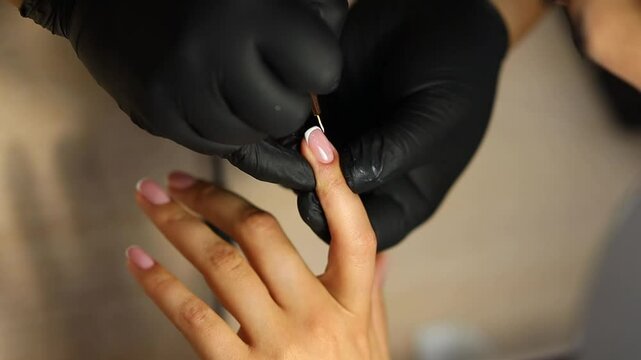 Women's manicure. Female hand undergoing a manicure procedure. The master does a women's manicure. A manicurist files a women's nails in a salon. Hygiene and hand care for woman. manicure design.