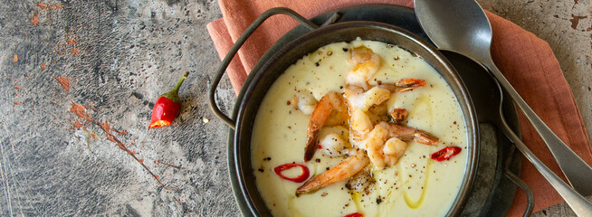 bowl of celery root soup with shrimp on table, top view
