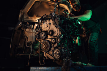 Mechanic pushing engine into car's body, vehicle repair process.