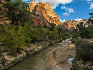 Virgin River flowing through the Zion Canyon in Utah, lined with high sandstone cliffs.