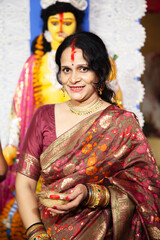 Obraz premium Beautiful Indian woman in traditional saree performing the Bengali ritual 