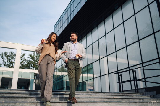 Business people walking and talking on stairs during coffee break