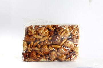 A close-up of a rectangular block of puffed rice treats. The treats are a golden brown color and are coated in a sticky, sweet substance. The block is sitting on a white background.