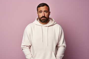 Obraz premium Portrait of a glad man in his 30s sporting a comfortable hoodie isolated in pastel or soft colors background