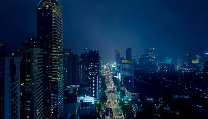 Naklejka premium Aerial shot of city skyline at night with traffic at streets, fog and rainy weather