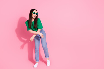 Full length photo of cheerful pretty lady dressed green t-shirt dark eyewear having fun empty space isolated pink color background