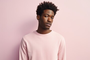 Obraz premium Portrait of a tender afro-american man in his 20s showing off a thermal merino wool top in front of pastel or soft colors background