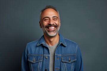 Fototapeta premium Portrait of a joyful man in his 40s sporting a rugged denim jacket on minimalist or empty room background