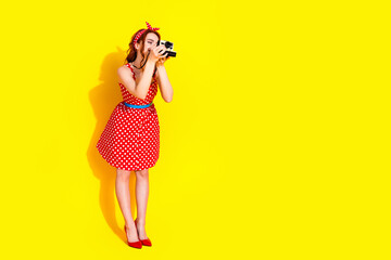 Photo of lovely pretty lady wear red trendy clothes hold camera take picture empty space isolated on yellow color background