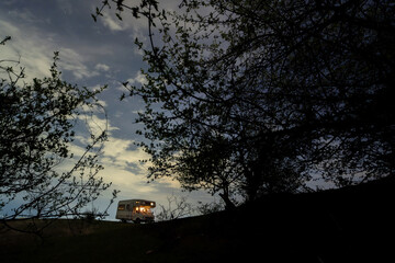 Motorhome camping in the mountains at night, under the starry sky