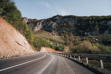 good asphalt road in the mountains on a sunny day, solid marking line, mountains of Georgia