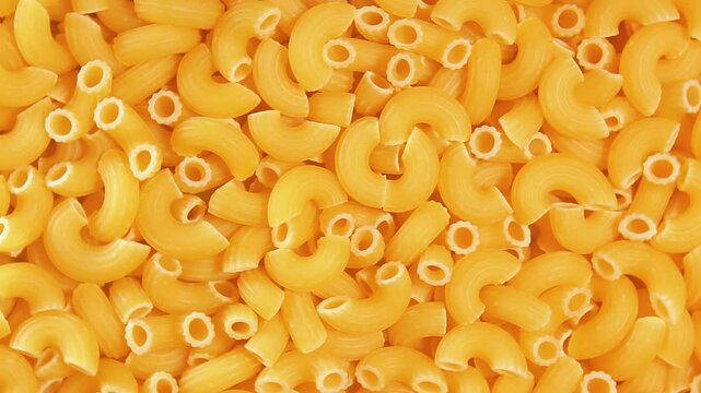Uncooked Chifferi Rigati Pasta - Top View, Close-Up. Fat and Unhealthy Food. Classic Dry Macaroni, Slowly Rotating Background. Italian Culture and Cuisine. Raw Golden Pasta Texture - Right Rotation