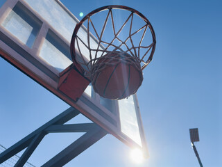 Basketball scoring a basket as it goes through the hoop and making a swish in the net