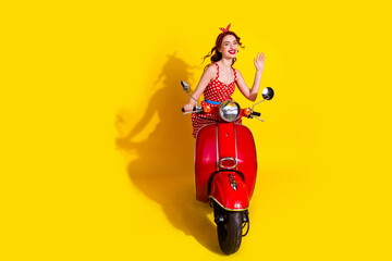 Photo of pretty cute positive lady wear red stylish sarafan riding moped isolated on yellow color background