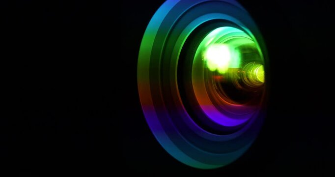 Spectral decomposition of light. Projector lens in operation, close-up zoom-in shot video. Dispersion - decomposition of light into spectral colors