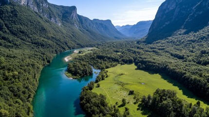 Aerial view of a lush green valley surrounded by mountains and a river flowing through the landscape.