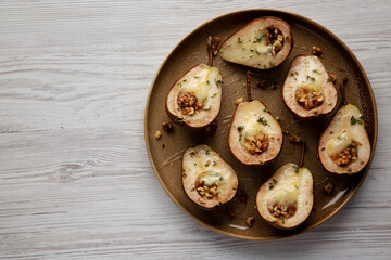 Homemade Blue Cheese Stuffed Pears with Honey, Thyme and Walnuts on a Plate, top view. Copy space.