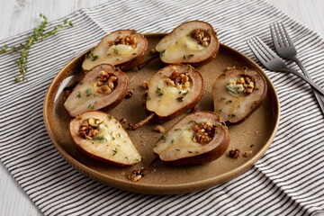 Homemade Blue Cheese Stuffed Pears with Honey, Thyme and Walnuts on a Plate, side view.