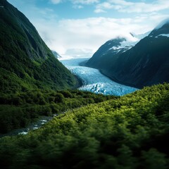 Fototapeta premium Stunning view of a glacier flowing through lush green mountains under a clear blue sky.