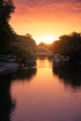 Fototapeta premium Sunrise behind the Butterfly Bridge passing over the River Great Ouse on the Embankment at Bedford, England