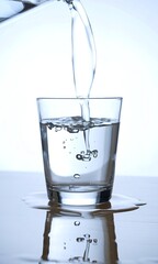 Pouring water on a glass on white background