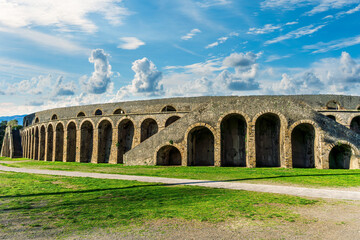 landscape of old ancient building of Roman arena with greeen grass foreground and  beautiful blue cloudy sky background