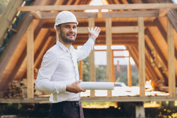 Construction engineer in white helmet. Developer with construction documentation on the background...