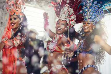 Fototapeta premium Women, happy and samba costume for dance, carnival and culture with celebration, confetti and music. People, smile and traditional outfit for performance, festival and parade event in rio de janeiro