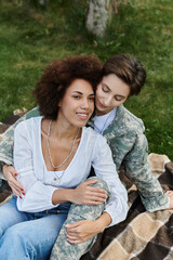 Naklejka premium A soldier in camouflage shares a heartfelt moment with her wife upon returning home.