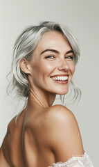 Fototapeta premium Close-up portrait of a confident middle-aged woman with silver hair, smiling brightly. Her glowing skin and joyful expression radiate vitality and beauty