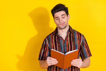 Photo of nice young man read book think wear shirt isolated on yellow color background