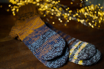 Handmade knitted socks against a background of soft, warm light. A cozy winter accessory with colorful patterns, ideal for the cold season. The close-up texture of wool creates a feeling of coziness 