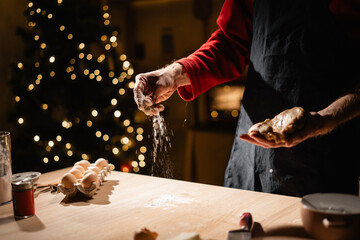 man is cooking gingerbread cookies or baking Christmas cake or strudel in the kitchen. low key