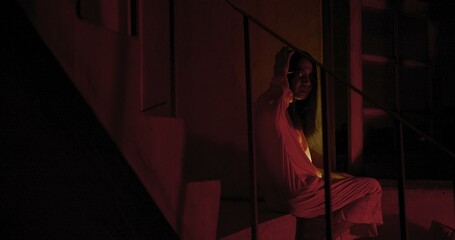 Horror scene of a mysterious Scary Asian ghost woman creepy have hair covering the face sitting on...