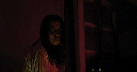 Horror scene of a mysterious Scary Asian ghost woman creepy looking to camera with dark scene movie...