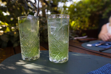 green mojito in a glass on a stand in a restaurant. Refreshing soft drink