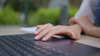 Girl hands using touchpad laptop at street cafe closeup. Unknown woman fingers 