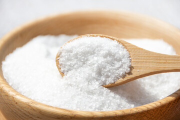 Salt in a wooden spoon close-up.
