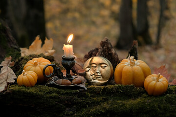 burning candle, moon amulet and decorative pumpkins in forest, autumn nature background. Samhain, Halloween. Witchcraft, esoteric spiritual ceremony. magic ritual. witch aesthetic. autumnal equinox