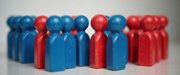 Painted red and blue wooden figures grouped together, symbolizing the divide between political parties or ideologies.

