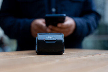 Customer using smartphone to make contactless payment in a cafe