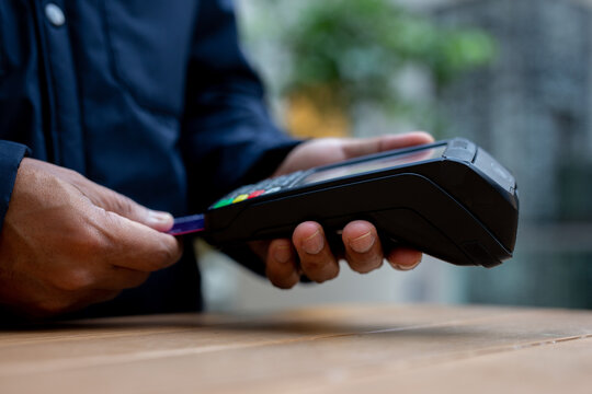 Customer inserting credit card in dataphone for contactless payment