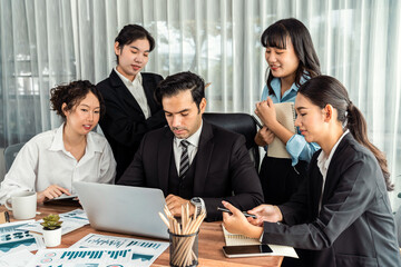 Diverse group of business analyst team analyzing financial data report paper on office table. Chart and graph dashboard by business intelligence analysis for strategic marketing planning Meticulous