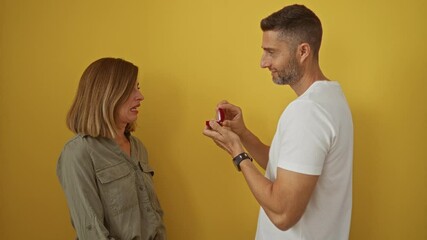 Man proposing to woman with ring on yellow background, showing surprise and rejection emotions, representing relationship moments and love