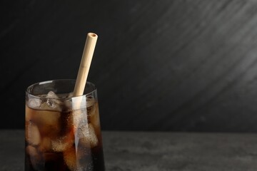 Tasty refreshing drink with straw in glass on grey table, closeup. Space for text
