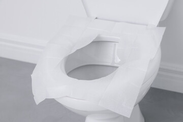 Toilet seat with paper tissues in bathroom
