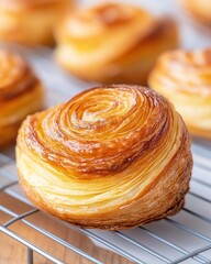 Delicious Kouign Amann pastries cooling on a wire rack in a cozy kitchen