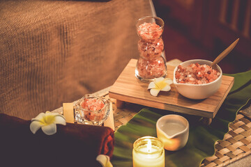 Exfoliation treatment in luxury spa salon with warmth candle light ambient. Salt scrub beauty treatment composition table in Health spa body scrub. Quiescent