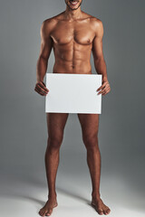 Man, naked and blank board in studio for body positivity, announcement and advertising acceptance...
