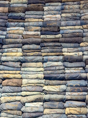 Stacked folded jeans in various shade of blue, creating a textured denim pattern. High quality photo